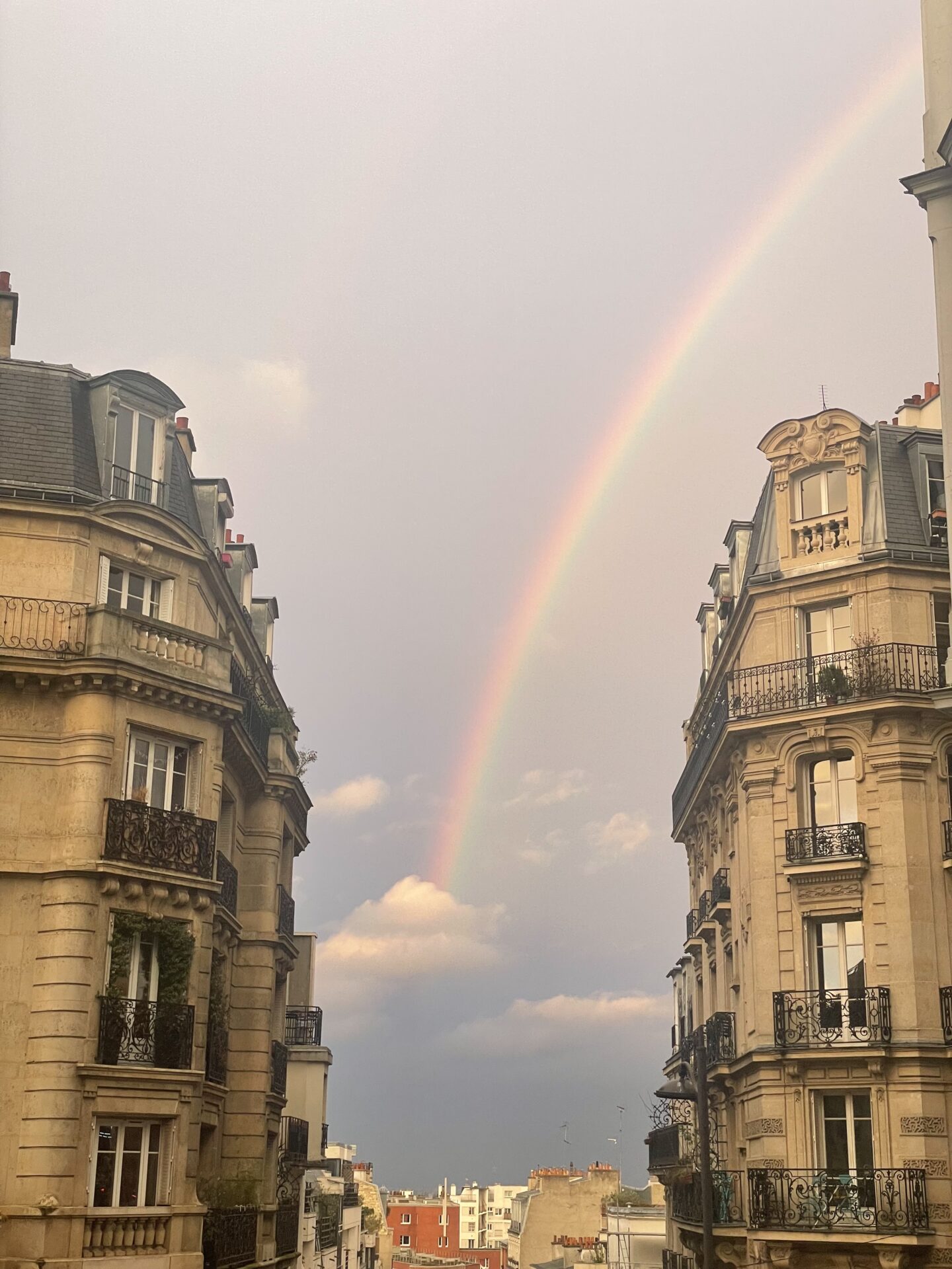 Vibrant rainbow over Paris Montmartre, 2024. Stunning colorful arc spanning the sky with Montmartre's iconic rooftops below. Photo by Leah Gillis.