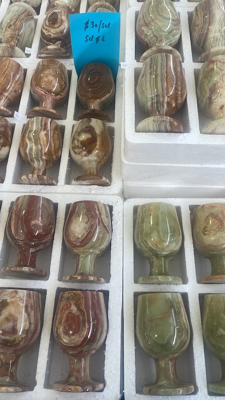 Brilliant natural stones and polished gems in display cases at Tucson, where buyers source rare minerals and jewelry-grade materials.