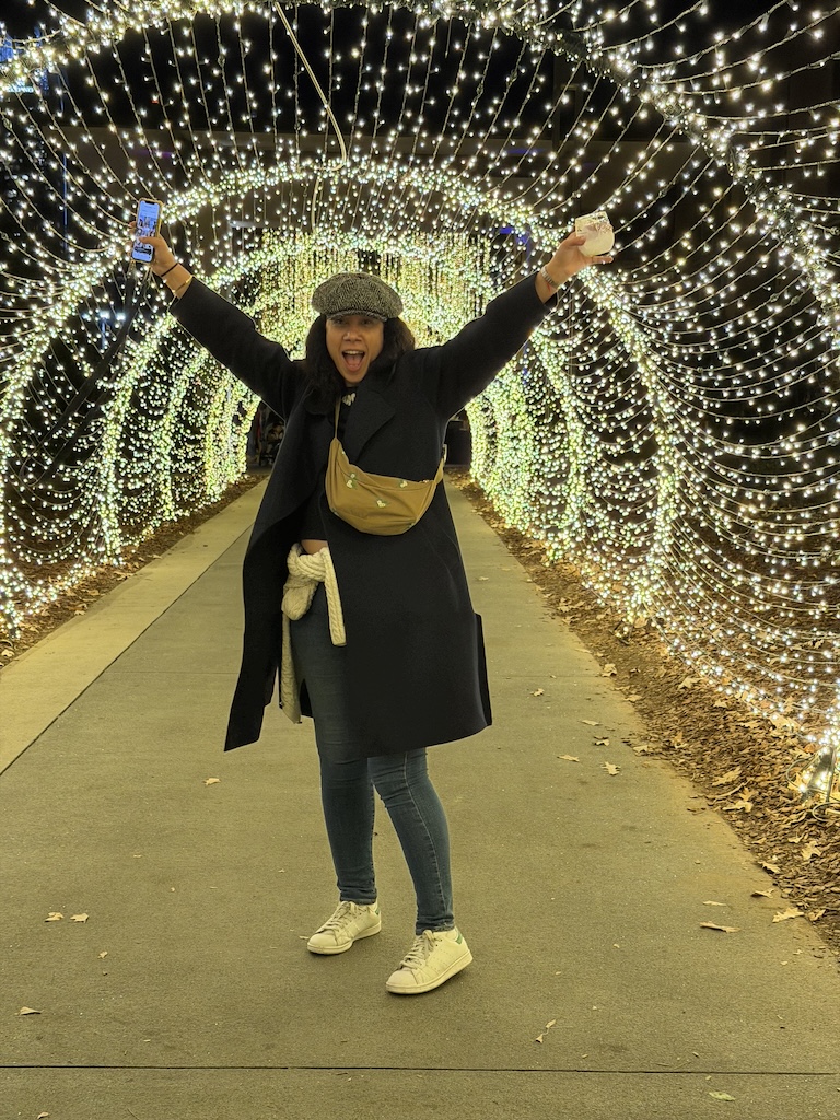 Me living my best life at the Atlanta Botanical Garden at night with the skyline glowing