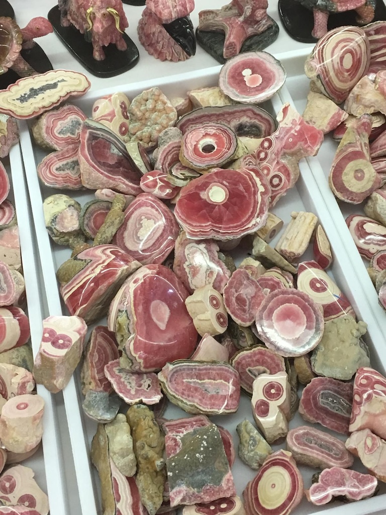 Close-up of extraordinary mineral specimens at the Tucson Gem Show, known for rare crystals, gemstones, and one-of-a-kind earth treasures.