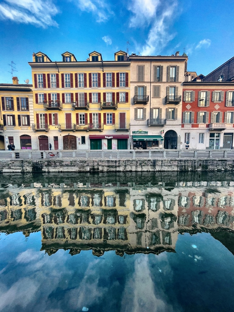 Reflections of historic Milan buildings in the Navigli canal, designed by Leonardo da Vinci — a hidden gem of spiritual and cultural travel in Italy