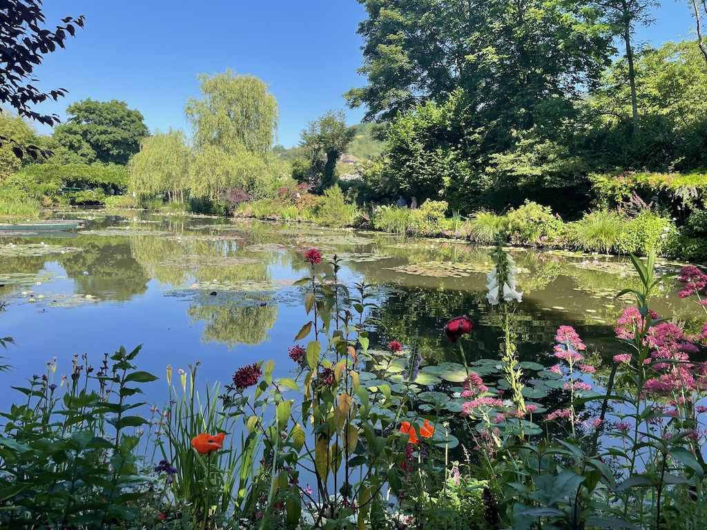 Claude Monet's garden pond at Giverny reflecting lush greenery -- a meditation on self and mirror, created by one of history's most iconic Aries