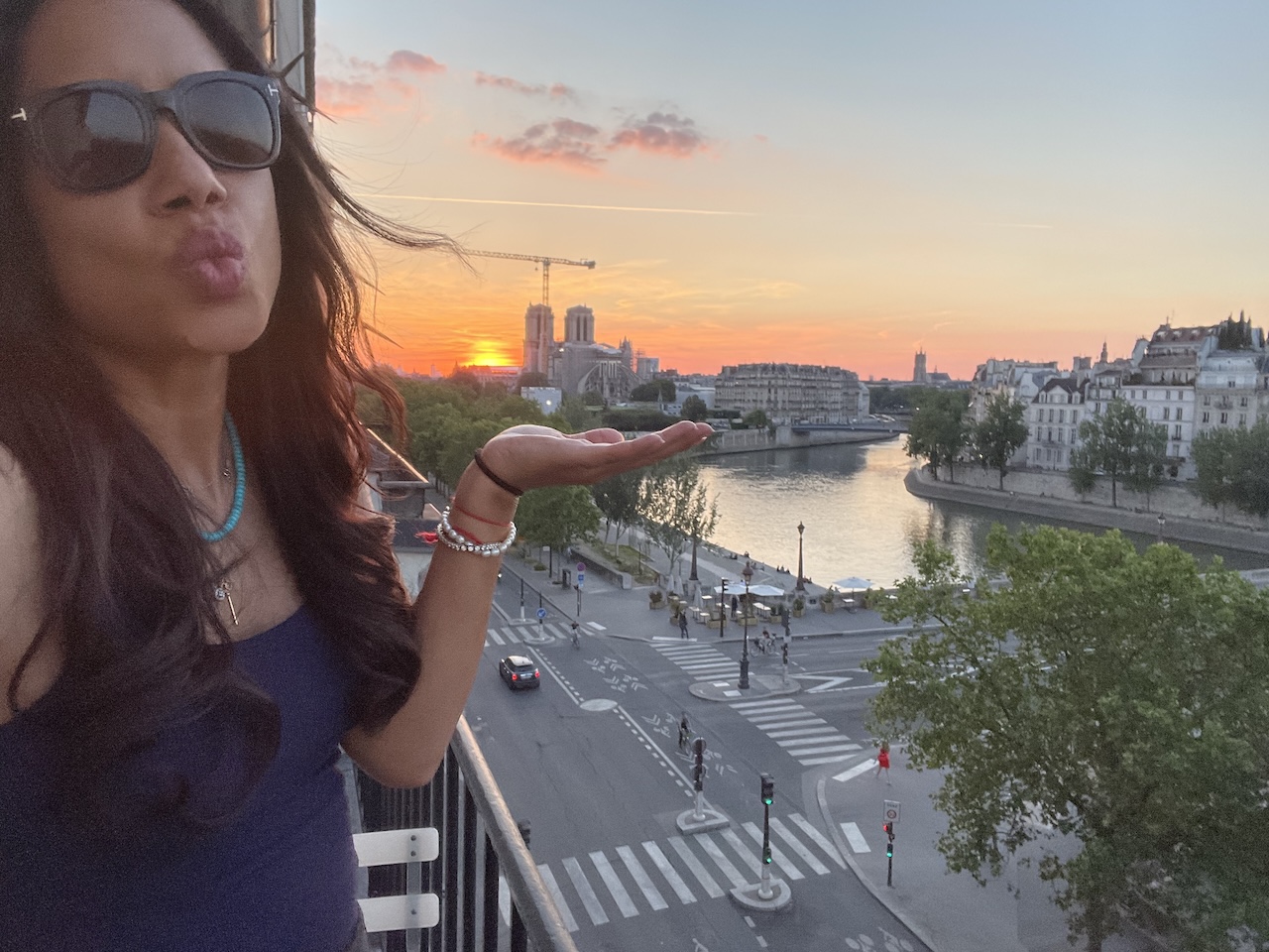 View of Notre Dame and the Seine from Paris Airbnb window, iconic cityscape at golden hour