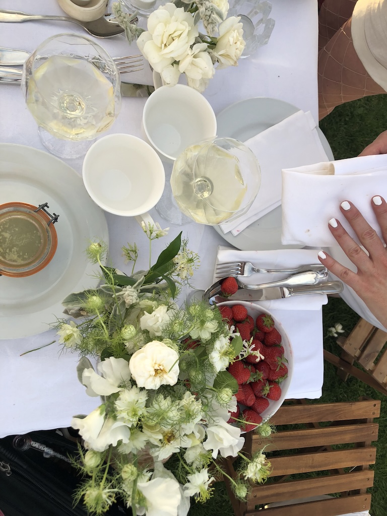 Elegant tables overflowing with flowers, champagne, and French cuisine at Dîner en Blanc Paris 2018. The festive atmosphere highlights one of Gemini's greatest gifts: bringing people together through conversation, curiosity, and memorable social experiences. Photo by Leah Gillis, The Diamond Is You.