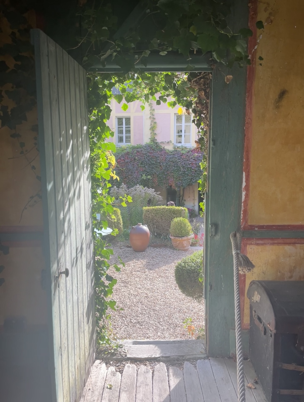 Open doorway of an artist's studio in Giverny, France, looking out onto a blooming garden.