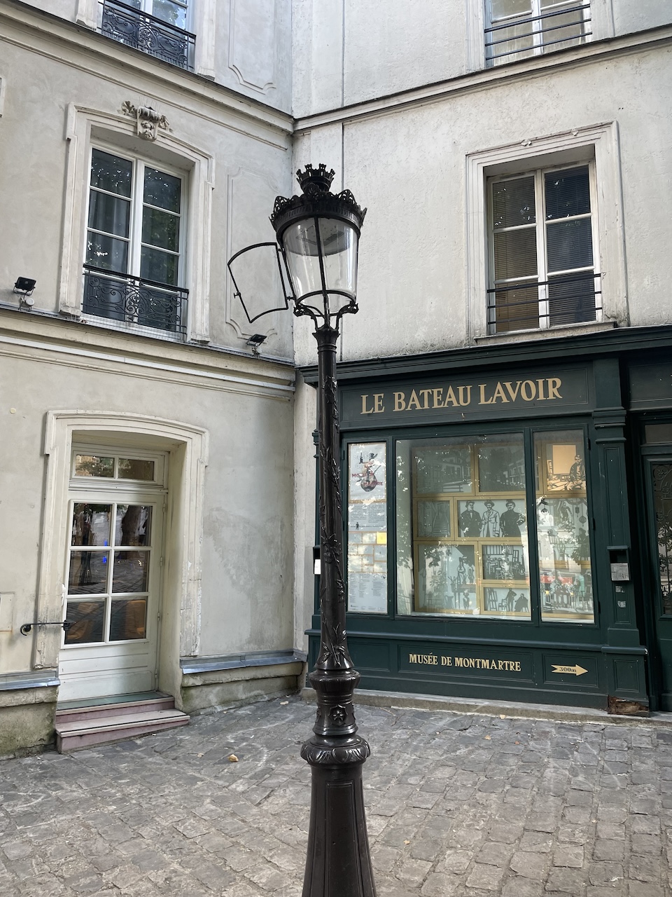 Historic Bateau-Lavoir building in Montmartre with an old lantern and open doorway.