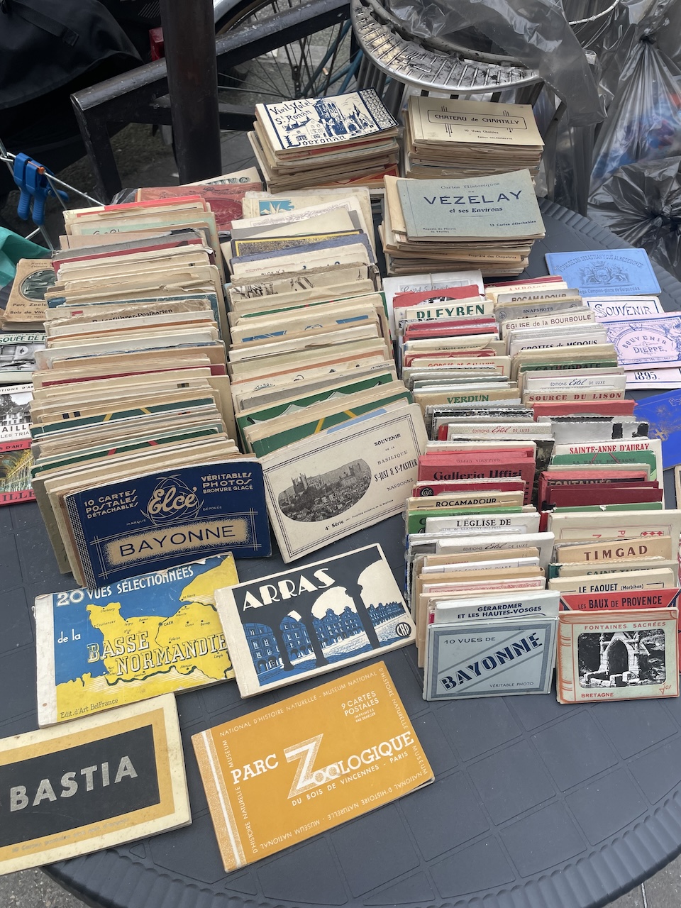 Close-up of vintage trinkets and antiques displayed at a Paris flea market stall" Caption: Every flea market table is a tiny museum curated by someone with better taste than a department store. Ten minutes in and I've already talked myself into three things I didn't know I needed.