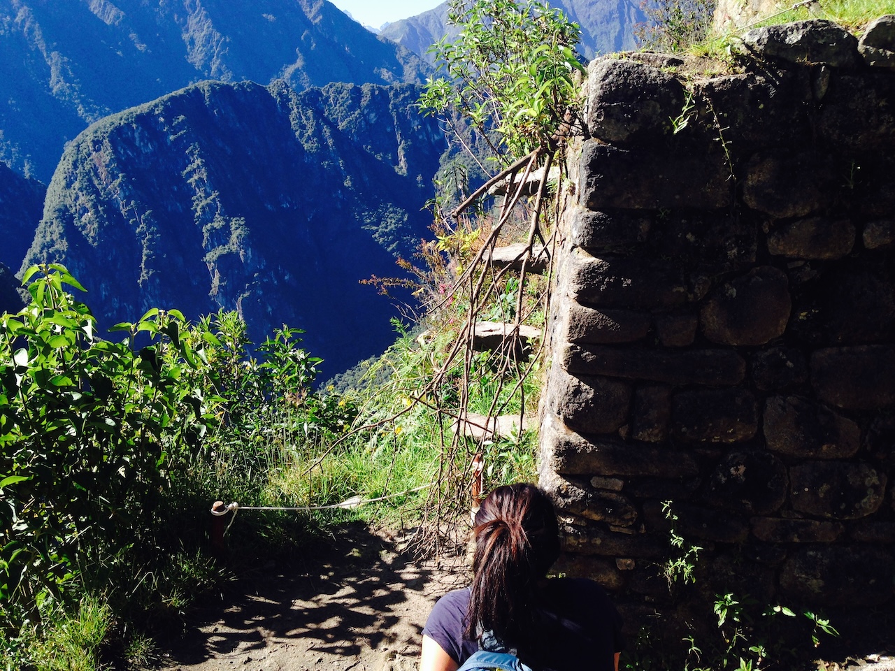 Leah Gillis hiking the stone steps of Huayna Picchu at Machu Picchu, Peru, with the Andes mountains behind her.